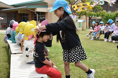 手作りのメダルを新入園児にプレゼントする在園児